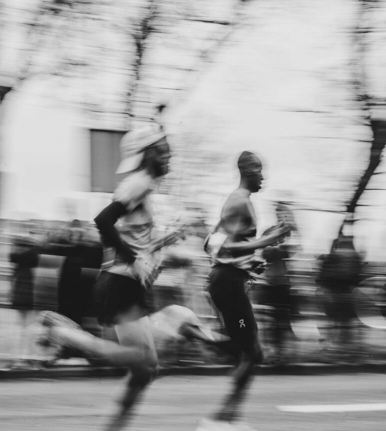 Coureurs traversant la ville, photographie en noir et blanc